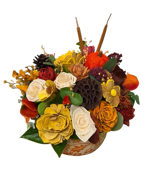 Harvest Glow fall wood flower arrangement with gold, ivory, orange and burgundy blooms, greenery and natural accents in a decorative fall leaf motif planter.
