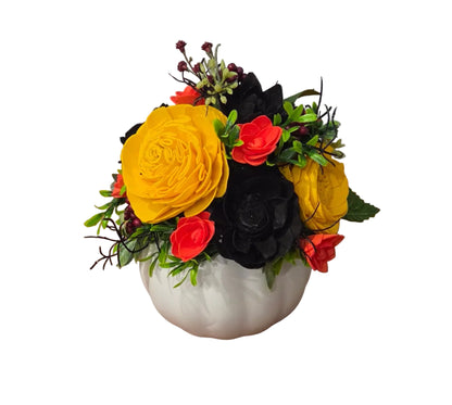 Back view of Hocus Pocus orange, yellow and black wood flower arrangement with berries and greenery in a white ceramic pumpkin.