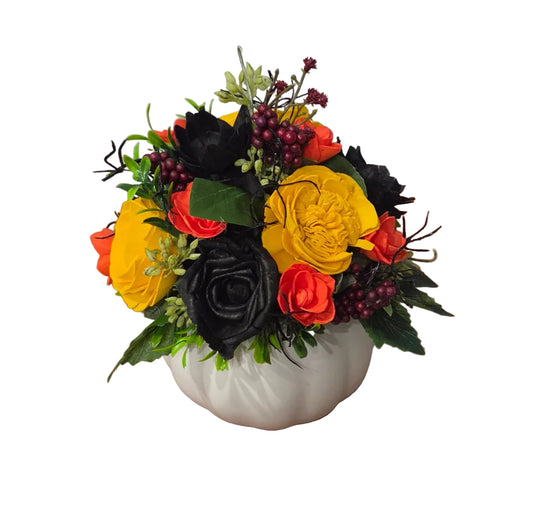 Hocus Pocus orange, yellow and black wood flower arrangement with burgundy berries and greenery in a white ceramic pumpkin.